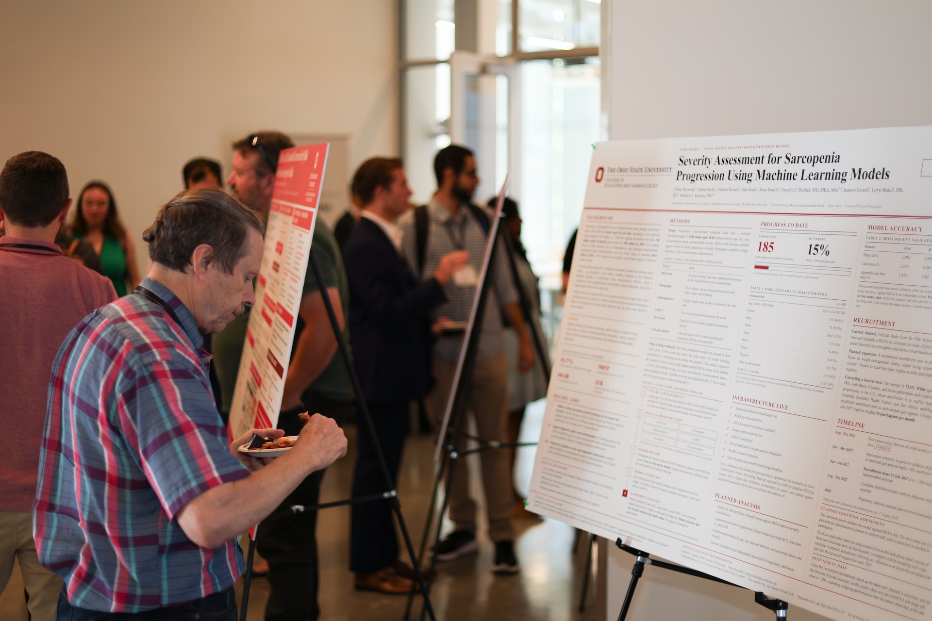 Attendee eating in front of poster, during poster session