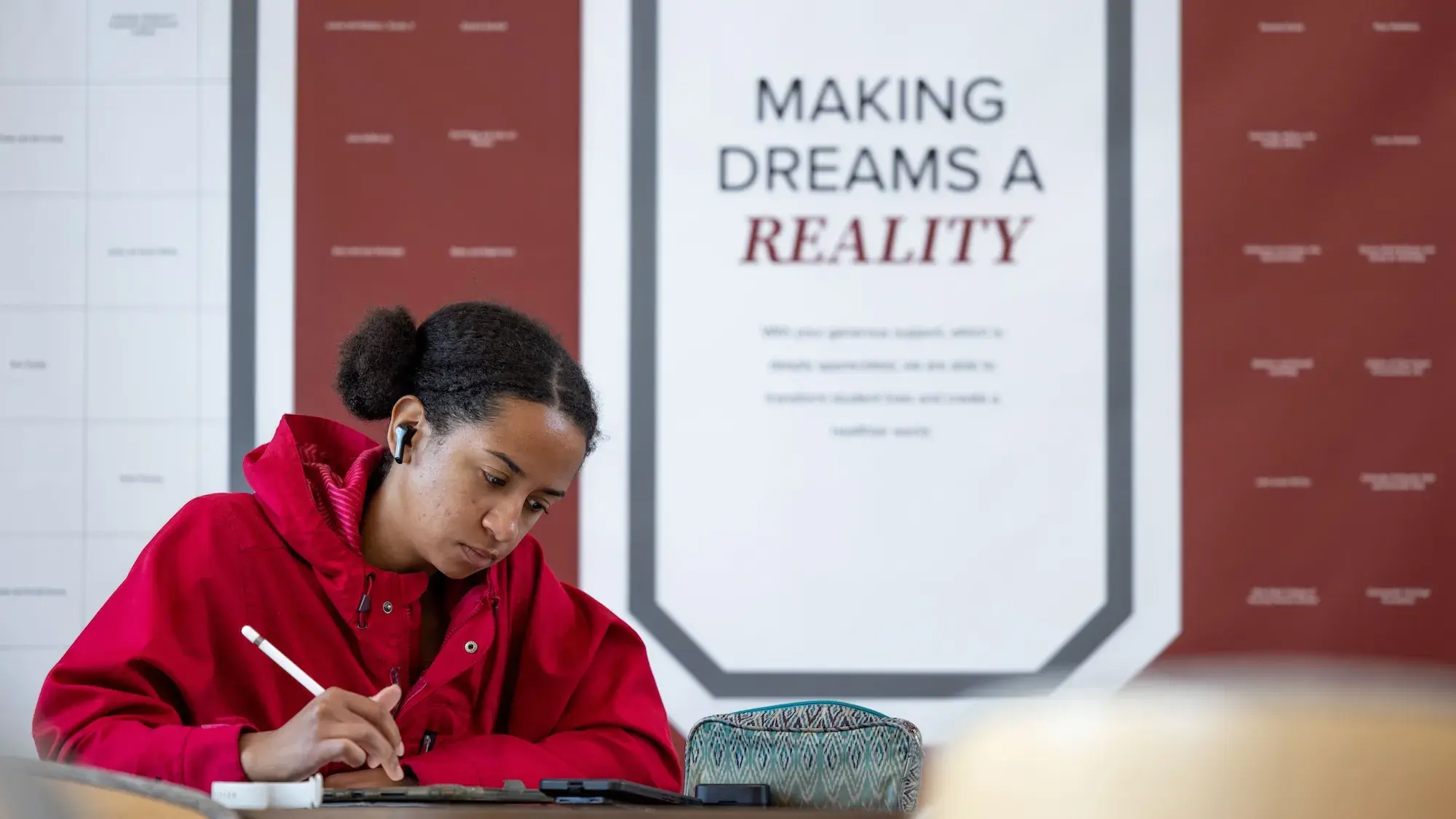 Student studying. Quote in background reads "making dreams a reality."