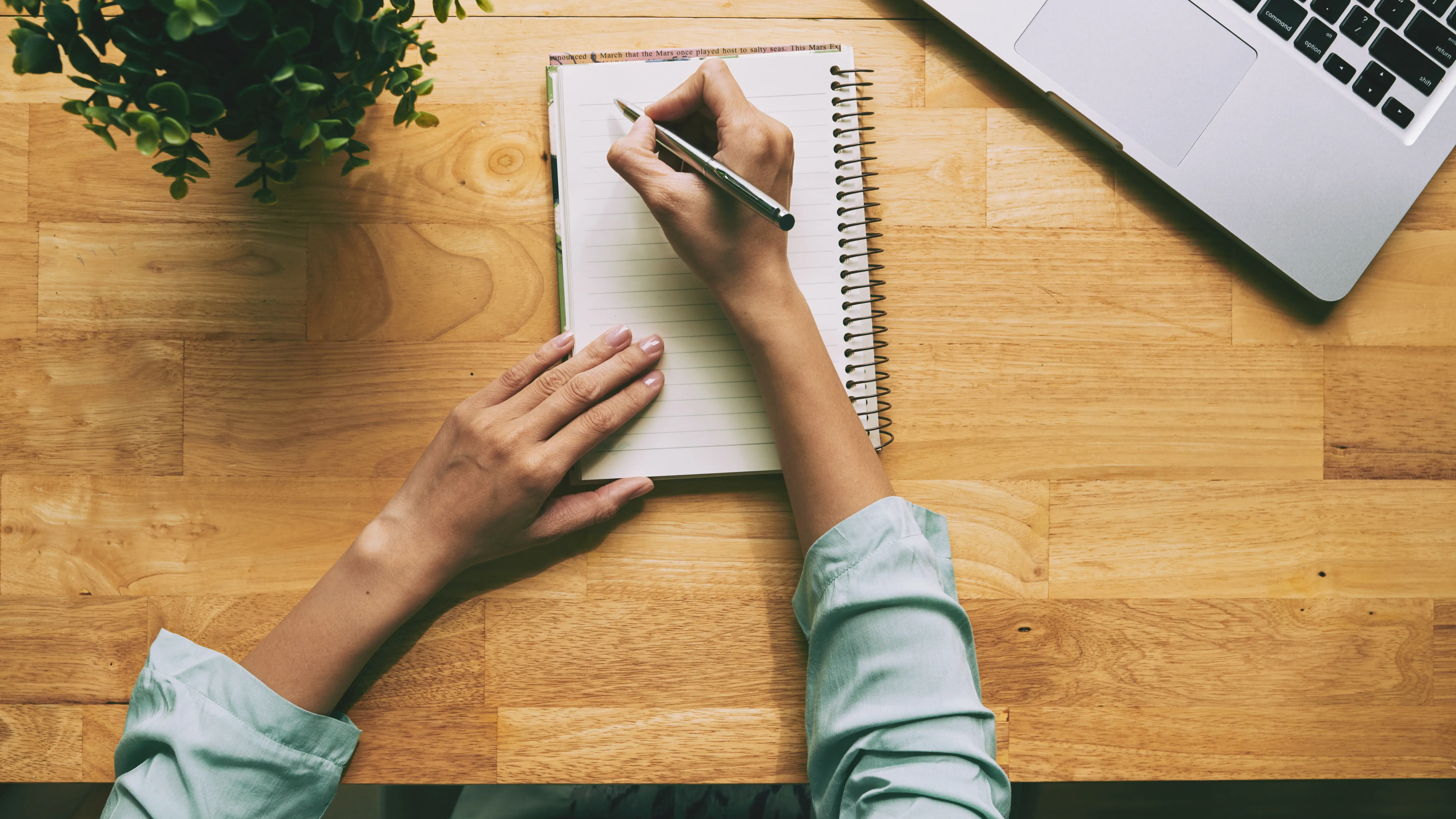 Person's hand writing on notebook