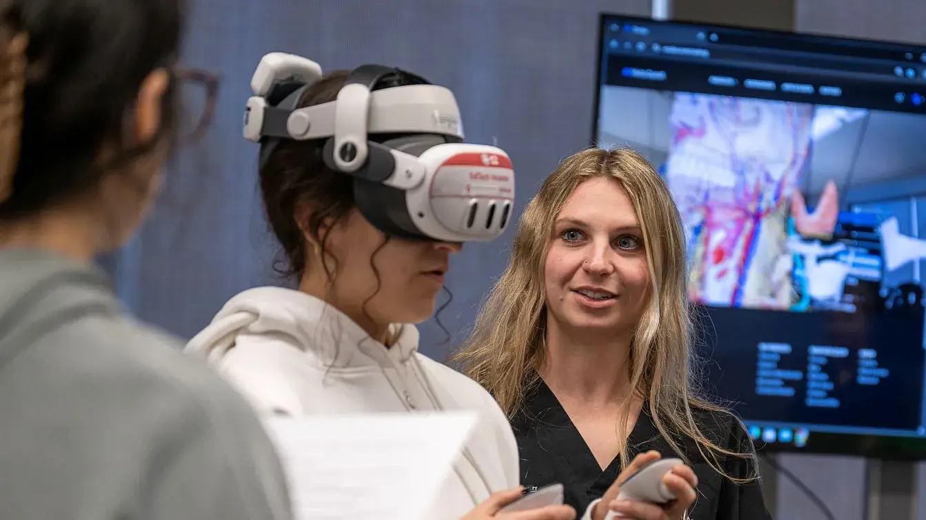 Jenna Kuczek engaging with a participant using a VR headset inside of the EdTech Incubator.